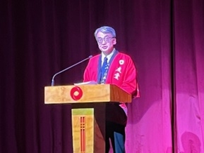 Embajador YAMAMOTO con hapi rojo, vestimenta tradicional japonesa, dirige sus palabras de saludo en el escenario