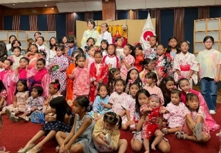 Foto grupal frente al adorno de muñecas Hina, con la esposa del Embajador, Sra. Hiroko, Presidenta de Fujinkai Sra. Ishihara y las niñas que participaron.