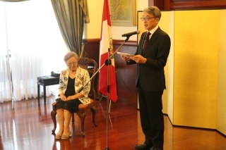Consejera Igarashi sentada, atenta a las palabras de felicitaciones del Embajador.