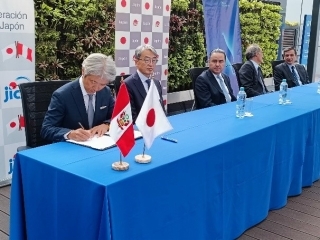 山元大使、国際金融公社(IFC)、BBVA Perúの代表者が横一列に座る中、署名をするJICA西村所長
