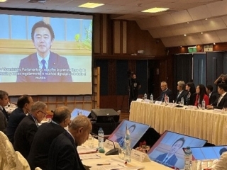 En la pantalla la imagen del Viceministro Parlamentario para Asuntos Exteriores de Japón Sr. HOSAKA Yasushi y los asistentes escuchando su mensaje.