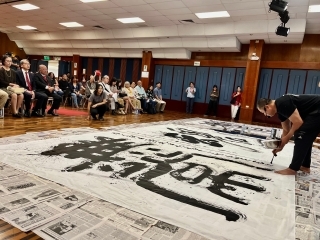 El maestro HAMANO Ryuho realizando la caligrafía en gran formato.