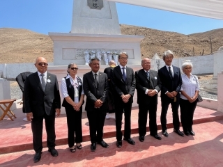 Los invitados de honor posan delante del monumento conmemorativo.