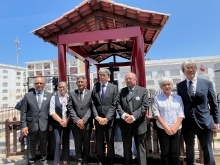 Los invitados de honor posan delante del monumento conmemorativo.