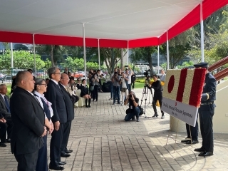 los invitados de honor se ponen de pie y van a hacer una reverencia hacia la ofrenda floral con el diseño de las banderas del Perú y Japón