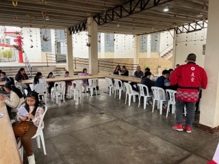 El instructor con happi, bata tradicional japonesa, dando indicaciones a los niños en su escritorio