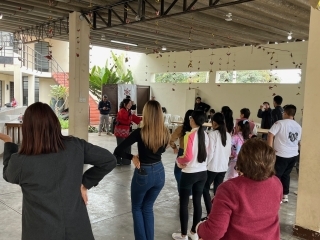 Los participantes de espalda practicando el baile bajo las indicaciones del instructor
