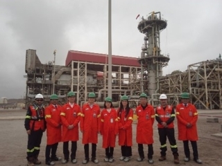 Foto grupal ante el gigantesco Intercambiador de Calor Criogénico Principal, el corazón de la planta de Gas Natural Licuado.