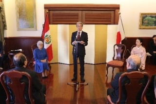 Consejera Saito sentada, atenta a las palabras de felicitaciones del Embajador que se encuentra de pie.