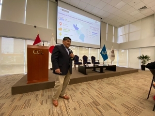 El Ministro Mucho exponiendo ante una gran pantalla