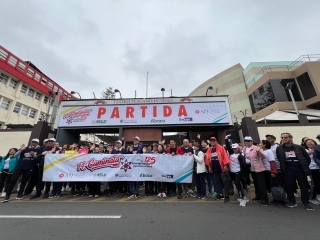 Una foto grupal de los participantes con una pancarta antes de la partida. 