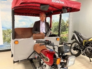 ホンダの三輪モデルの後部座席に試乗する山元大使