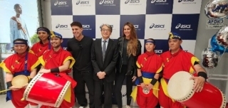 赤いハッピを着た太鼓パフォーマーたちと山元大使の記念写真