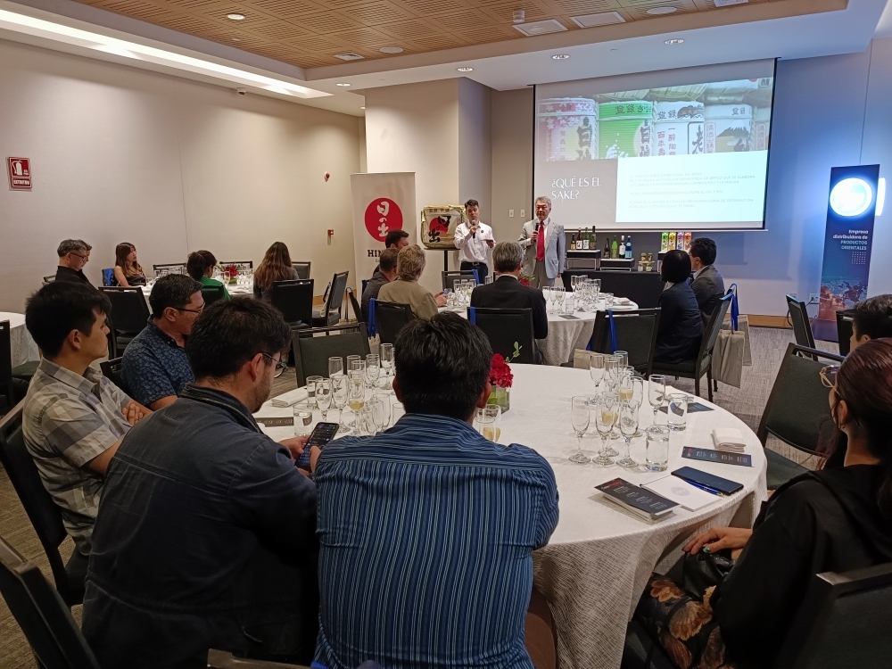 Los participantes del evento escuchando la explicación sobre el Sake