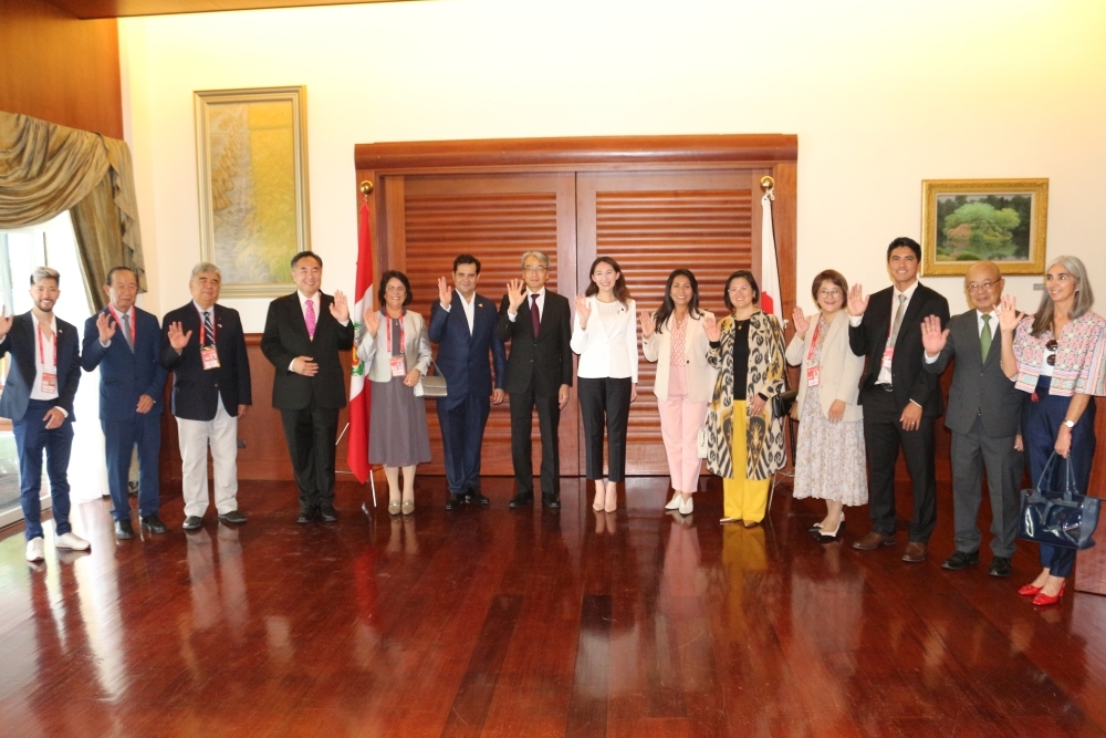 Toma de foto conmemorativa de la Viceministra parlamentaria Srta. ERI, el Embajador YAMAMOTO, representantes de cada país, el Presidente de AELU y otros representantes ubicados delante delas banderas del Japón y del Perú