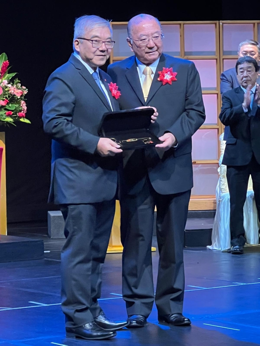 イゲイ新会長にオカダ前会長が鍵の入った箱を受け渡している