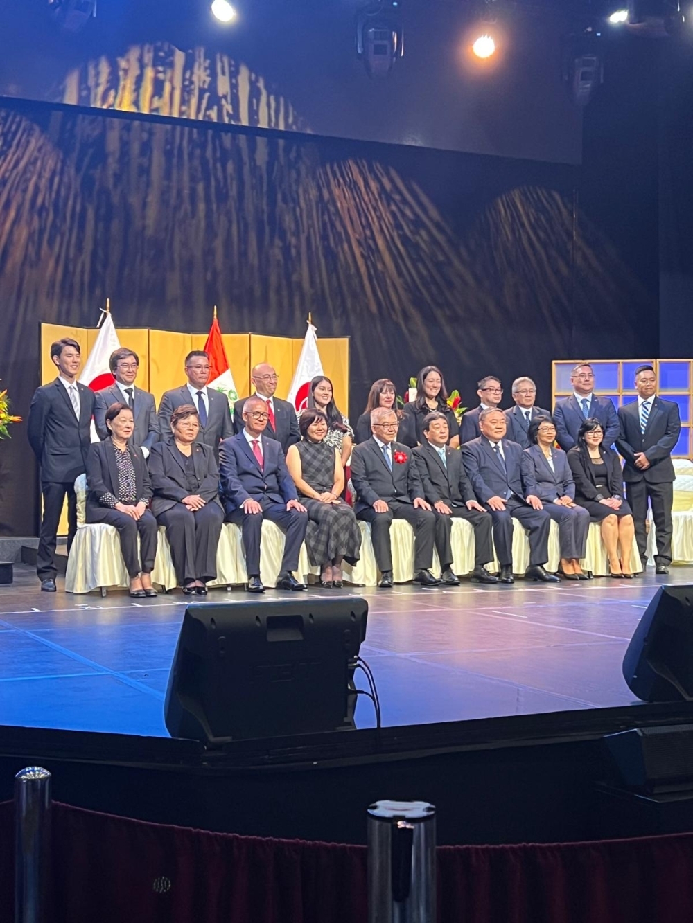 Toma de fotos conmemorativas de los nuevos directivos alineados en dos filas en el escenario