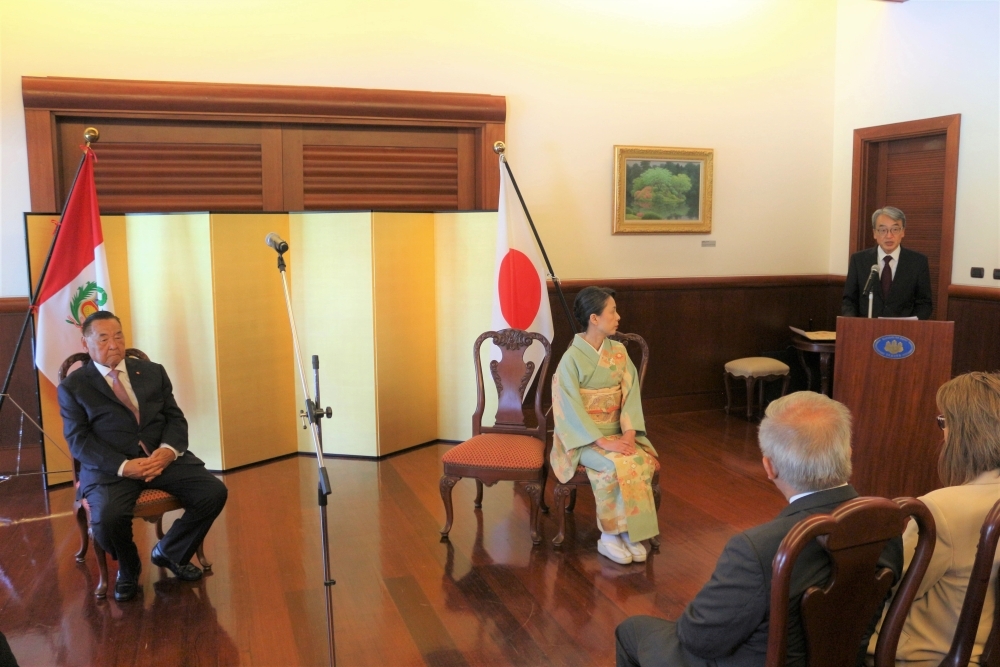 Consejero Yanaura y la esposa del Embajador Yamamoto sentados, atento a las palabras de felicitaciones del Embajador que se encuentra de pie.