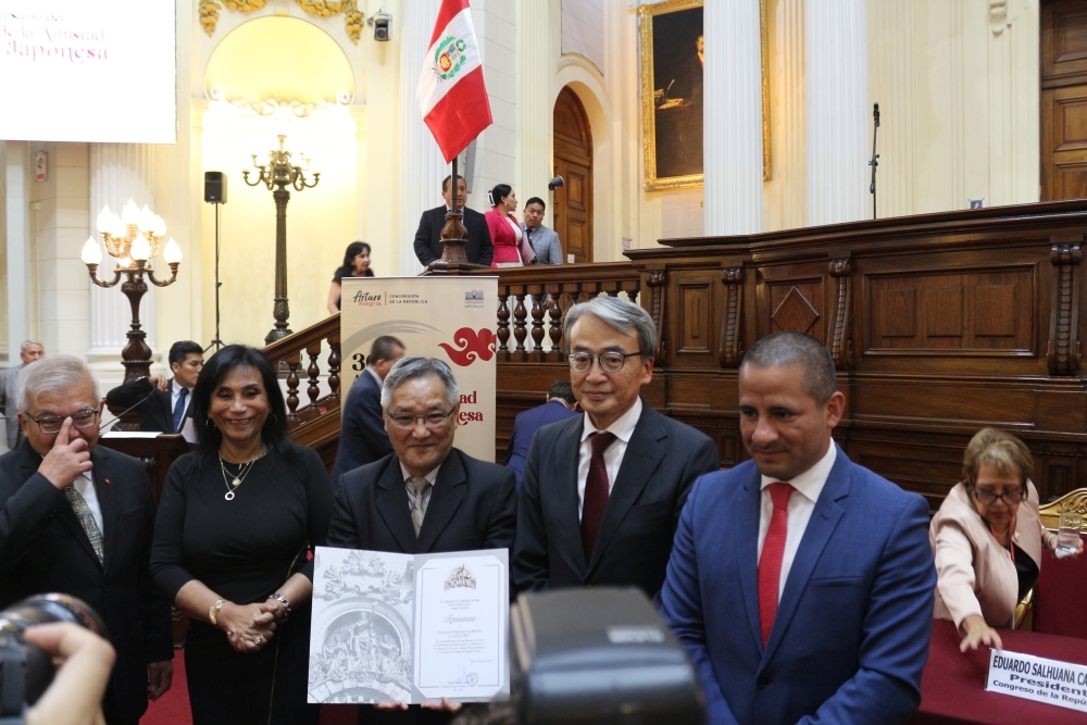 Entrega de reconocimiento por los integrantes de la mesa de honor