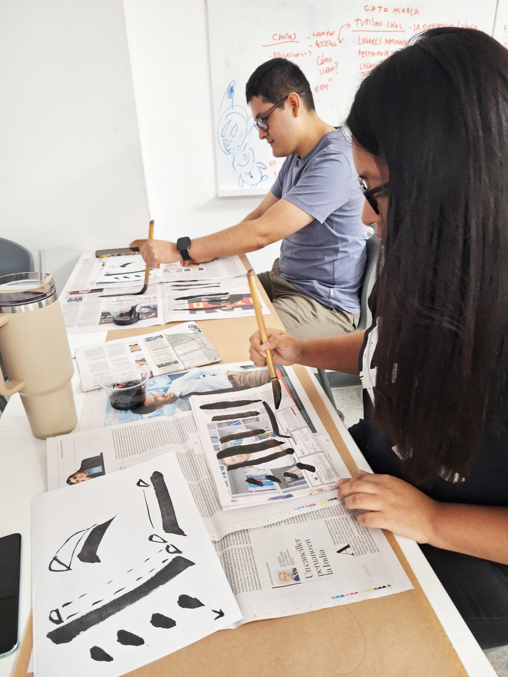 Los participantes del taller de la caligrafía japonesa están practicando la escritura del kanji