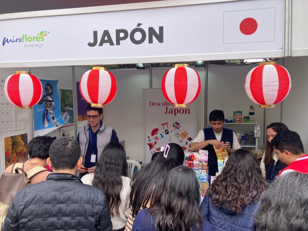 Funcionario de la embajada del Japón está atendiendo al público que visita el stand de Japón