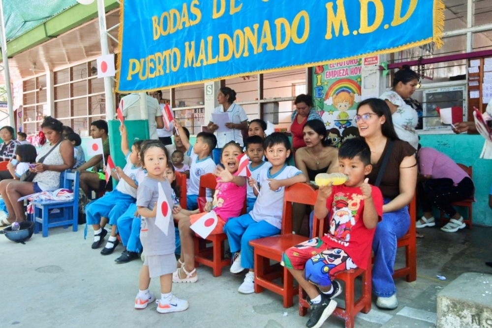 Los alumnos y sus madres teniendo las banderas del Japón y del Perú que participan en la ceremonia