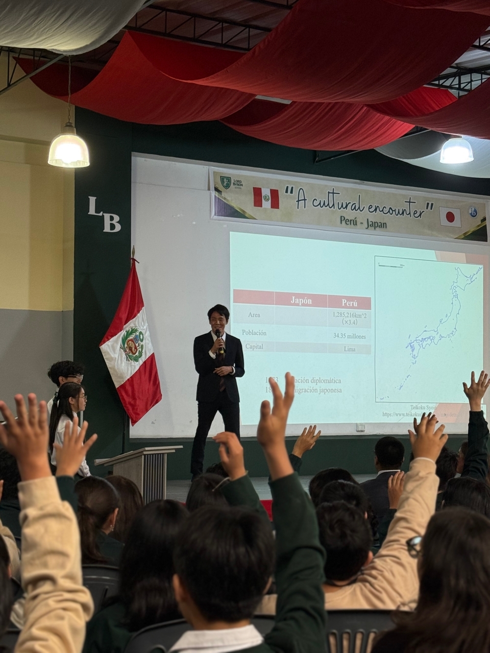 在ペルー日本大使館員が、ロード・バイロン学校の生徒の前で、日本文化に関する講演会を行っている。