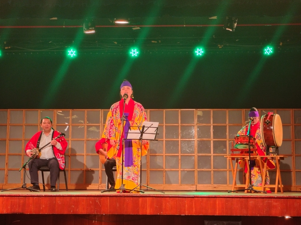 Presentación de canciones tradicionales de Okinawa a cargo de la voluntaria