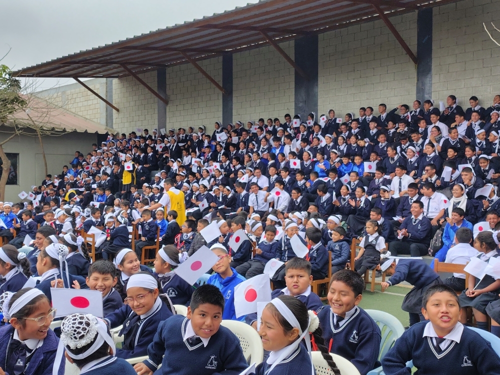 Los alumnos de I.E. COPRODELI San Juan Macías participando con banderas japonesas en el lugar de la ceremonia