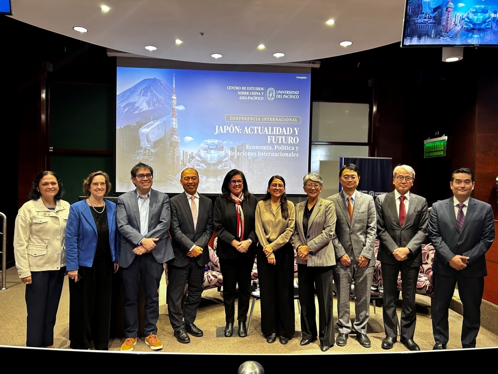 El Embajador YAMAMOTO se toma una foto protocolar en el escenario junto con los expositores y representantes de la Universidad del Pacífico