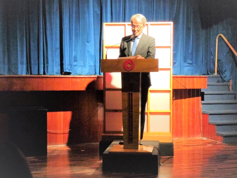 El Embajador YAMAMOTO está dirigiendo sus palabras de saludo en el estrado del Centro Cultural Peruano Japonés