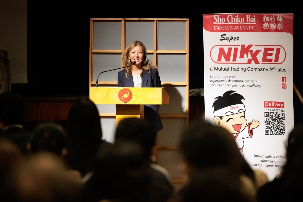 日秘文化センターの演壇で古川参事官が挨拶をしている