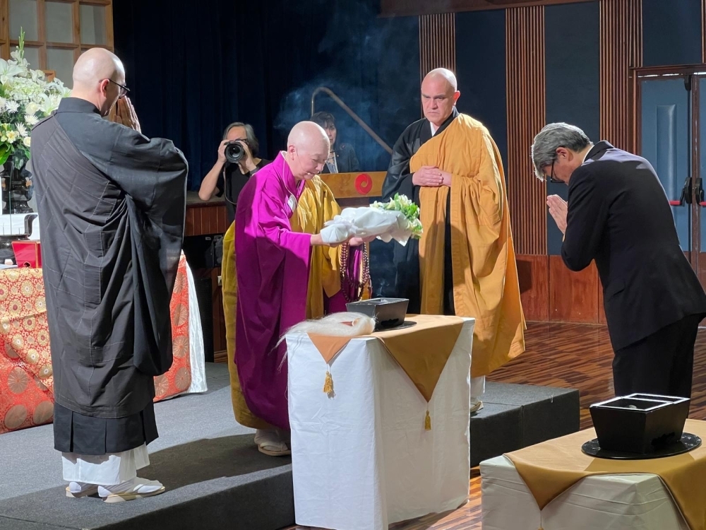 El Embajador YAMAMOTO ofrece flores y reza ante el altar