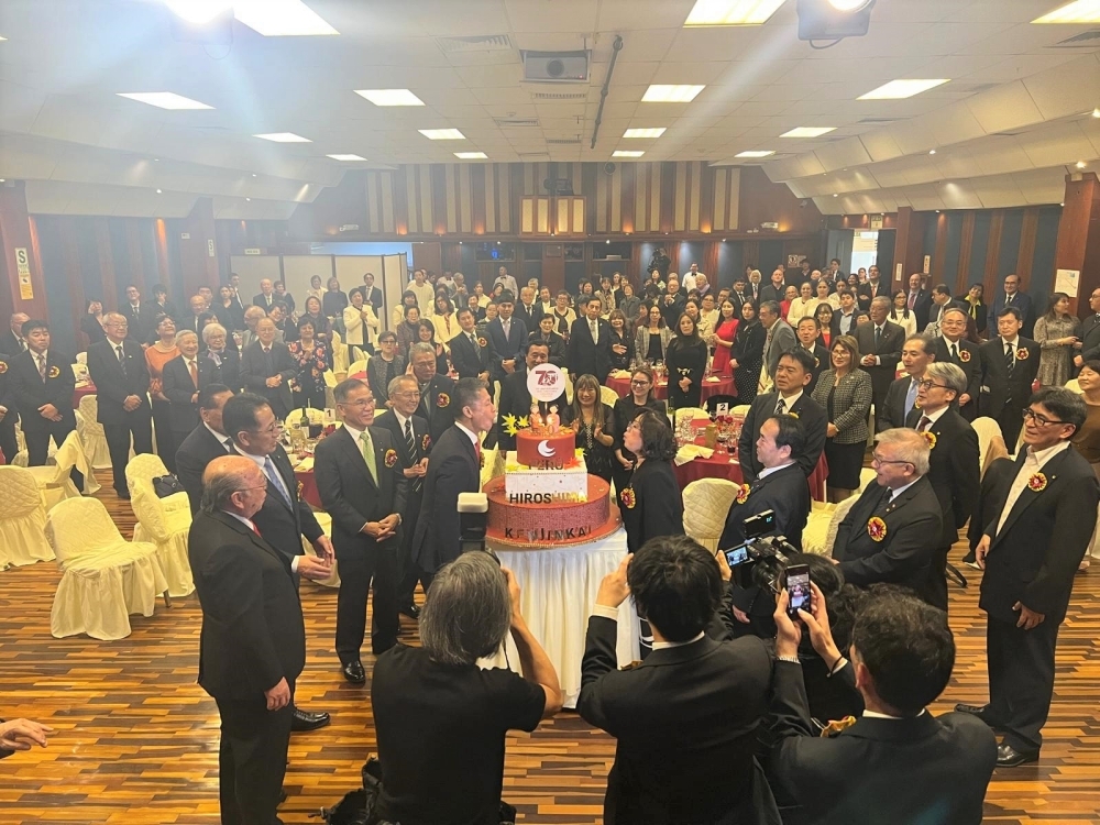 招待者がケーキを囲み、ペルー広島県人会の記念日を祝賀している様子