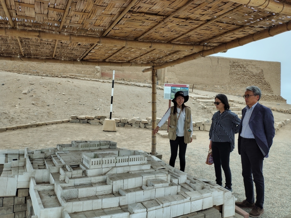 Embajador YAMAMOTO escuchando la guía de la voluntaria de JICA sobre el Santuario Arqueológico de Pachacamac