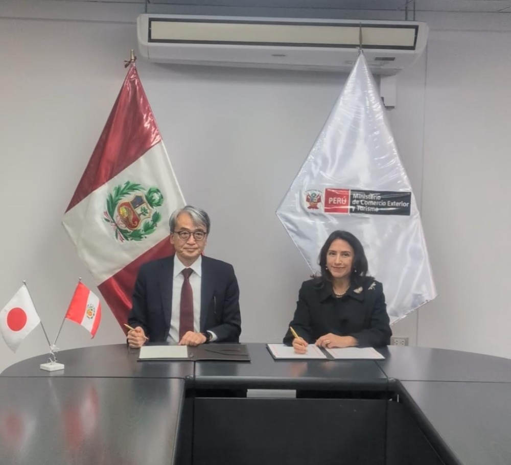 El embajador YAMAMOTO y la ministra de MINCETUR, Teresa Stella Mera Gómez, sentados lado a lado mientras firman el documento