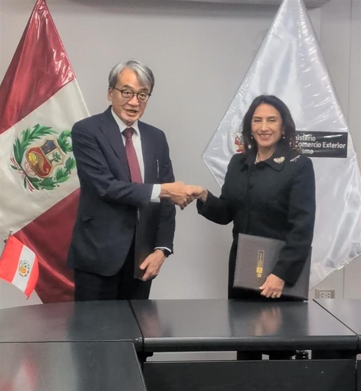 El embajador YAMAMOTO y la ministra Mera sonríen y se dan la mano después de la firma