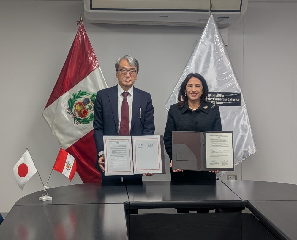 山元大使とメラ通商観光大臣が署名文書を披露している