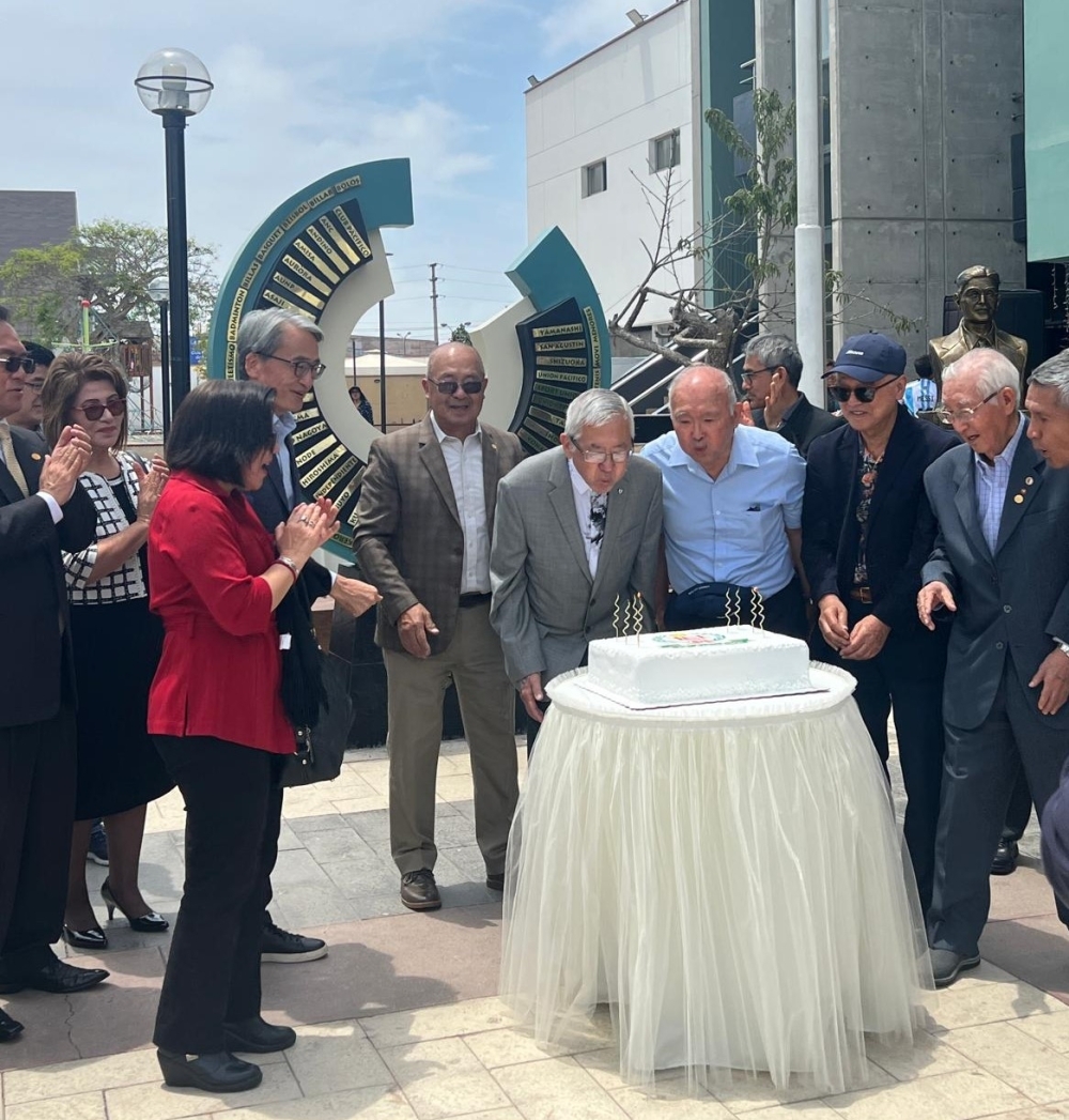 Los asistentes cantan Happy Birthday alrededor de la torta por su aniversario institucional