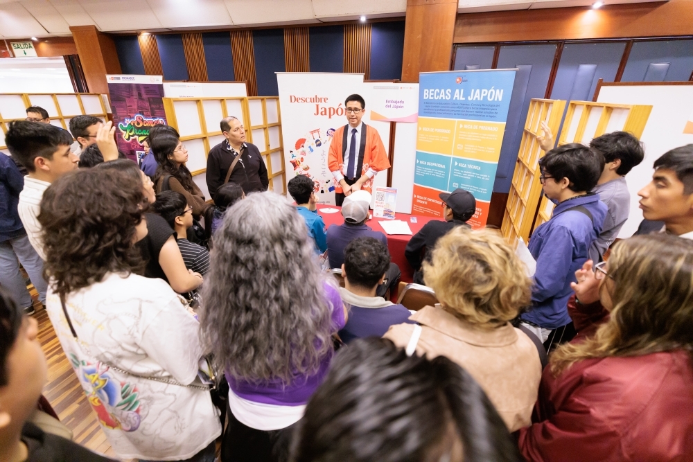 日本大使館のカラスコ現地職員が出展ブースで日本文部科学省が提供する奨学金制度を来場者に説明している。