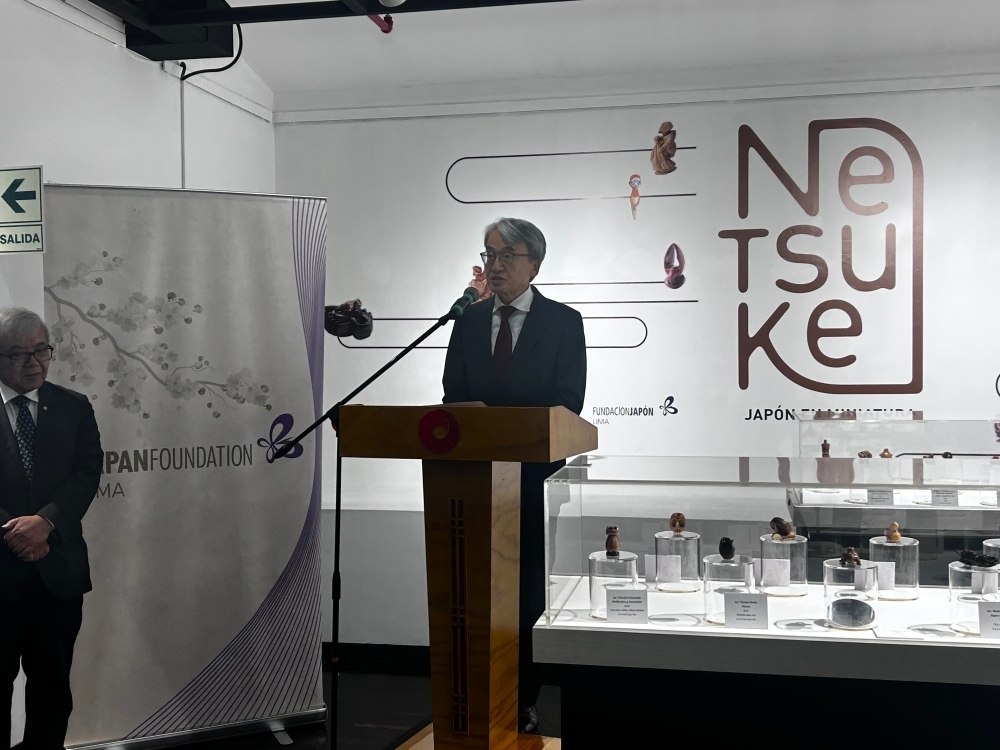 El embajador YAMAMOTO está brindando su discurso en la ceremonia de inauguración de la exposición Netsuke, frente a los asistentes.