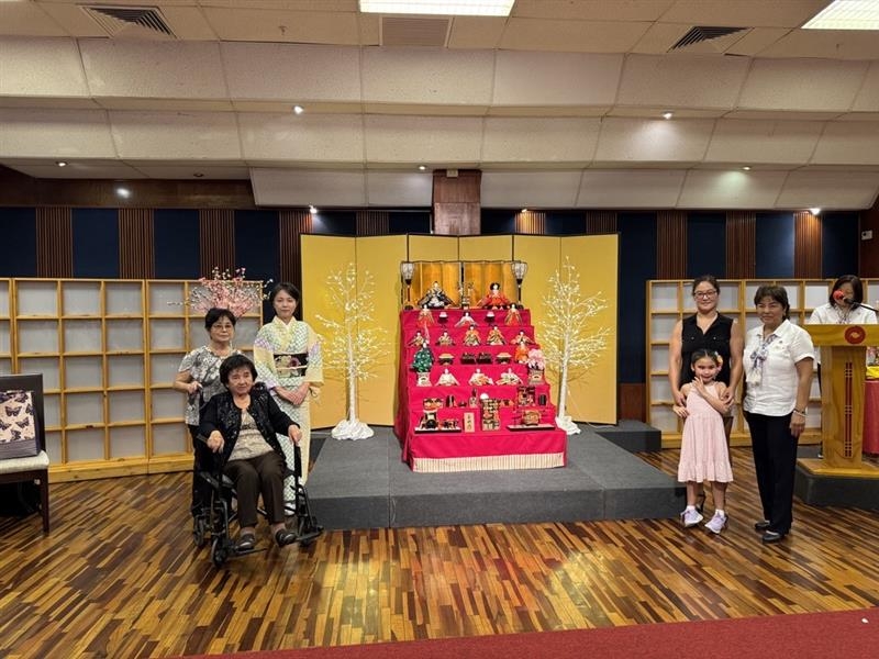 ひな壇を中心に四世代にわたり女児の誕生が続くご家族が記念撮影をおこなっている