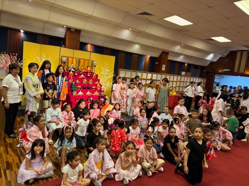 Con el altar de muñecas en el centro, un gran número de niñas participantes se reúne para una foto conmemorativa