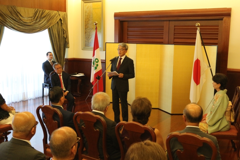 Abogado Dr. Toyama sentado, atento a las palabras de felicitaciones del Embajador que se encuentra de pie.