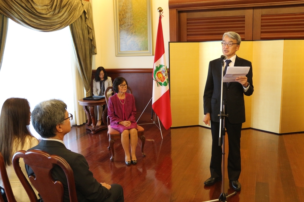 La señora Sakata y la esposa del embajador Yamamoto sentadas, atentas a las palabras de felicitaciones del Embajador que se encuentra de pie
