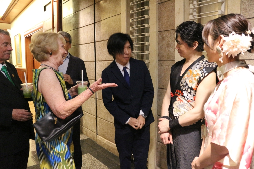 Los invitados a la recepción está degustando el té japonés en plena conversación con otros invitados.
