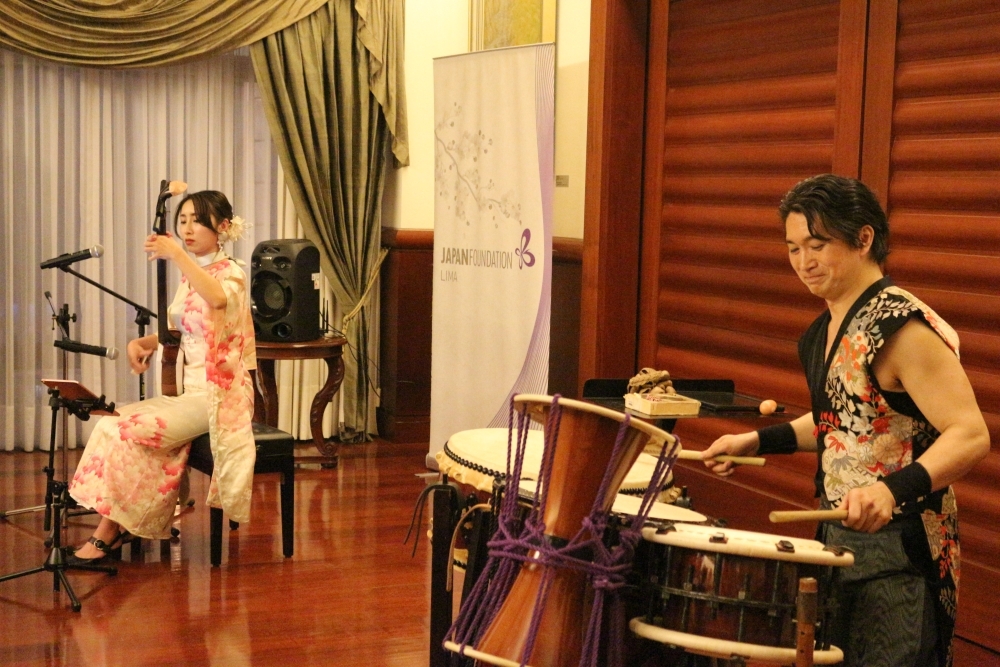 Srta.KOMADA Sayo, intérprete del instrumento japonés tsugaru shamisen, y Sr,KANAZASHI Keita, intérprete del tambor japones, taiko, están brindando una presentación artística en frente de los invitados.