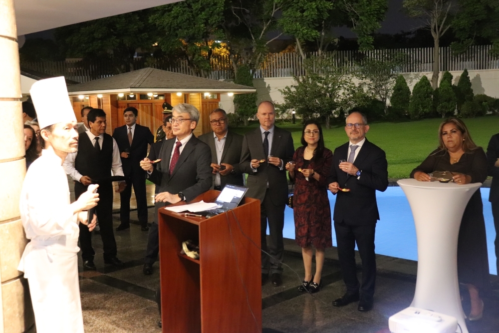 山本料理人が、参加者の前で試飲食用に提供された日本酒と料理のマリアージュについて説明している。