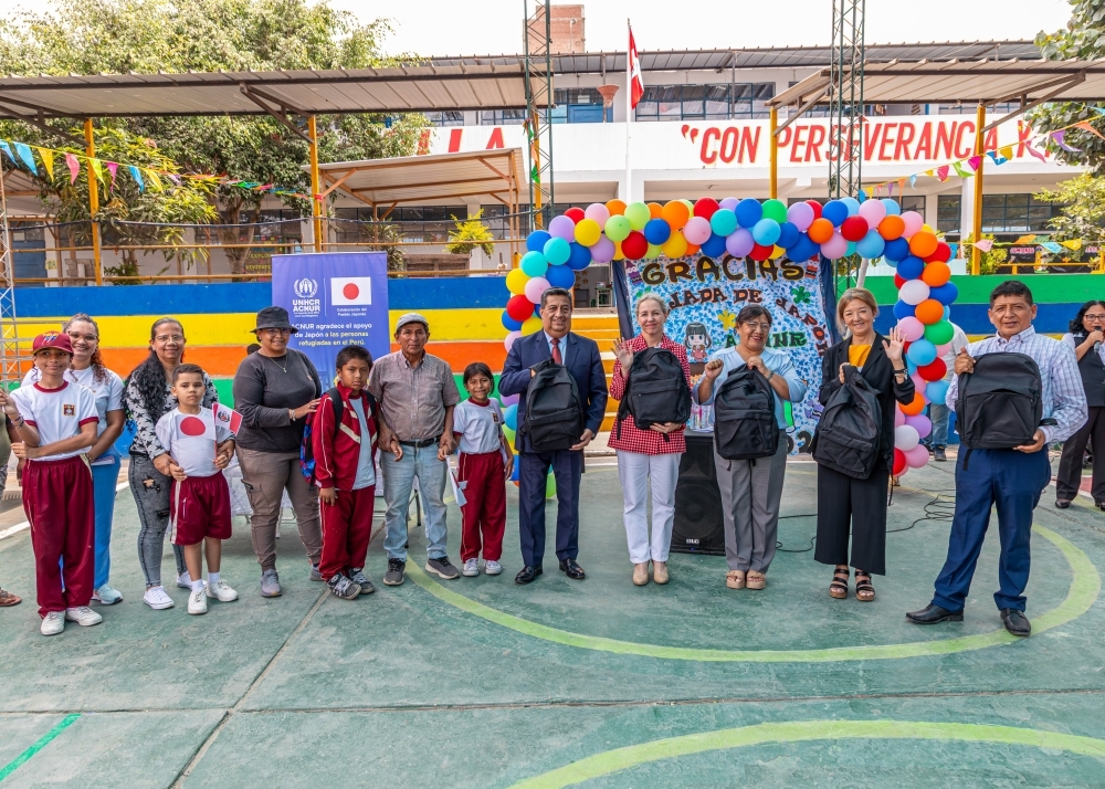 Los niños junto a la señora Laura Almirall, Representante de ACNUR en Perú y la consejera FURUKAWA con los kits escolares