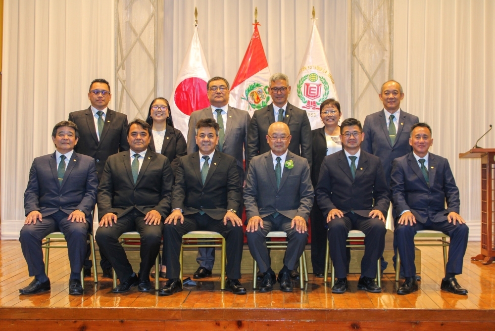 Toma de fotos conmemorativas de los nuevos directivos alineados en dos filas en el escenario